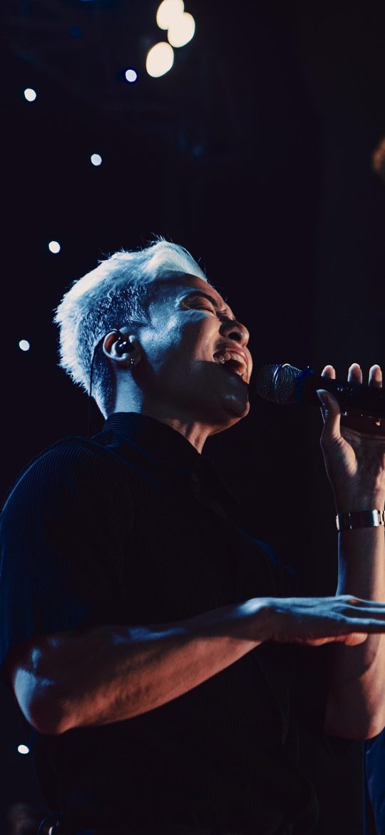 concert App 演出日历界面截图：深色背景上按月份排列的演出卡片，霓虹蓝高亮标记已关注场次